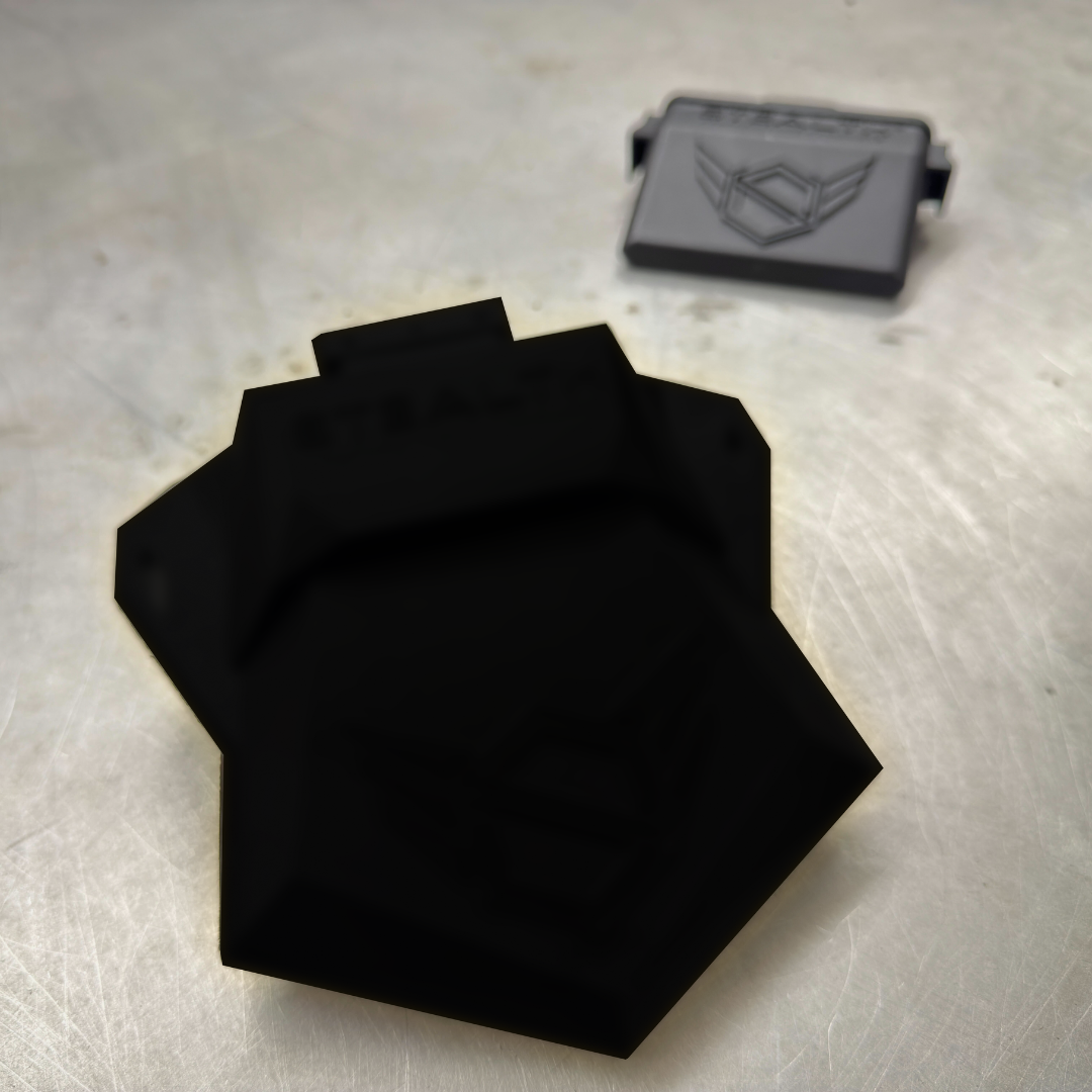 Black fabric on a metallic surface with a logo in the background